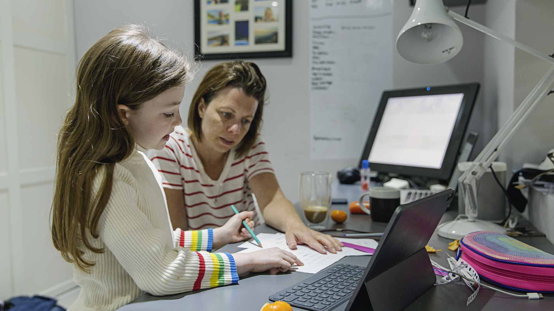 Image of young girls who is studying with the help of her mother